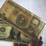 Un hombre sostiene billetes de peso y de dólar