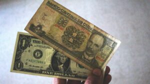Un hombre sostiene billetes de peso y de dólar