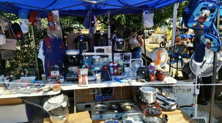 Mesa de venta con electrodomésticos y artículos del hogar en un mercado informal en La Habana