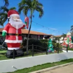 Decoración navideña exterior con Santa Claus inflable y árboles de Navidad