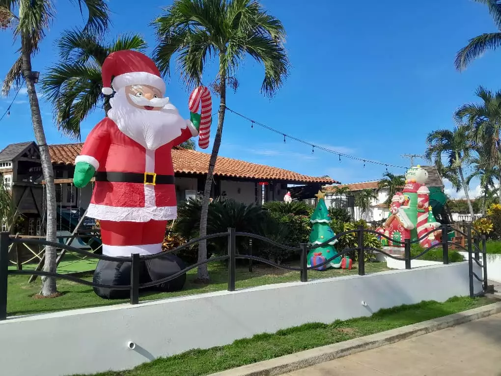 Decoración navideña exterior con Santa Claus inflable y árboles de Navidad