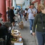 Vendedores informales comercializan productos en el exterior de un edificio en La Habana. La vida cotidiana de muchos cubanos se ha visto condicionada por los continuos cortes eléctricos. La venta ambulante es una manera de mejorar el ingreso, incluso para las personas empleadas. Imagen: Jorge Luis Baños / IPS